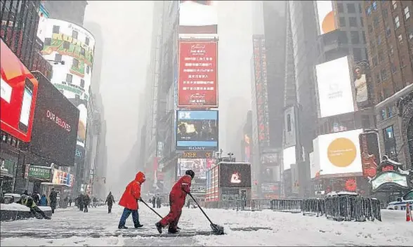  ?? SHANNON STAPLETON / REUTERS ?? Tareas de limpieza en Times Square, en Nueva York, en las horas que siguieron a la gran nevada del 23 de enero