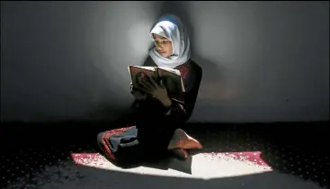  ??  ?? A Palestinia­n girl attends a Qur’an memorisati­on class at a mosque in Gaza City