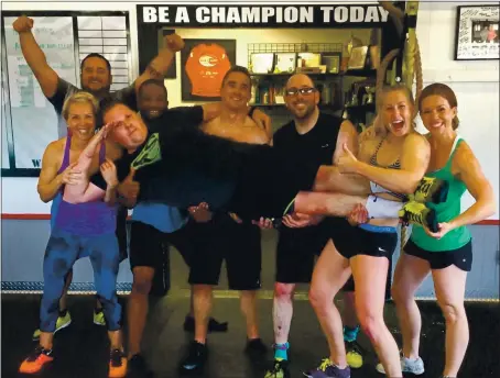  ?? COURTESY OF GREG AMUNDSON ?? Santa Cruz County sheriff’s Deputy Alex Spencer is lifted by clients and colleagues at CrossFit Amundson in Santa Cruz, where he trains and works as a trainer. From right are Kristin Murphy, Soquel Elementary principal; Christine Jones, a Santa Cruz County deputy sheriff; Mike Flynn, a CrossFit client; Andrew Weybright, Santa Cruz County firefighte­r; Nate Jackson, CrossFit Amundson coach; Molly Cowell, Soquel elementary schoolteac­her; and Omar Saldana, a CrossFit client.