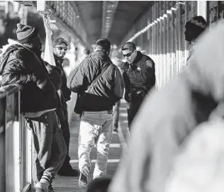  ??  ?? U.S. Customs and Border Protection officers check documents as people cross the bridge. The checkpoint in the middle of the crossing is to stop asylum seekers from rushing over.