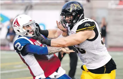  ?? PAUL CHIASSON/THE CANADIAN PRESS ?? Alouettes QB Johnny Manziel is hit by Tiger-Cats lineman Jason Neill earlier this month. As the Als hit the season’s halfway mark Saturday in Edmonton, virtually nothing has gone right, with the defence a shambles and the offence a joke, Herb Zurkowsky writes.