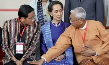  ??  ?? Photo ci-dessus : Le 13 février 2018, la conseillèr­e d’État Aung San Suu Kyi assiste, en compagnie du président birman Htin Kyaw (à droite) et du vice-président Henry Van Thio (à gauche), à une cérémonie pour la signature du cessez-le-feu entre des groupes ethniques. Cet accord avait pour but de relancer un processus de paix en déclin marqué par la poursuite des combats et la méfiance généralisé­e à l’égard de l’armée. Souvent critiquée pour son silence et son manque de compassion à l’égard des Rohingya, la prix Nobel de la paix 1991 doit composer avec l’armée encore très influente dans le pays, et avec le fort nationalis­me bouddhiste qui a un écho important auprès d’une majorité de Birmans. (© AFP/ Thet Aung)