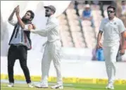  ?? AFP ?? A fan clicks a selfie with Virat Kohli as R Ashwin watches on the first day of the second Test in Hyderabad on Friday.