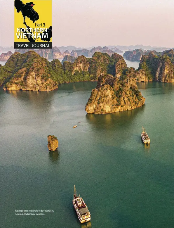  ??  ?? Passenger boats lie at anchor in Bai Tu Long Bay, surrounded by limestone mountains.