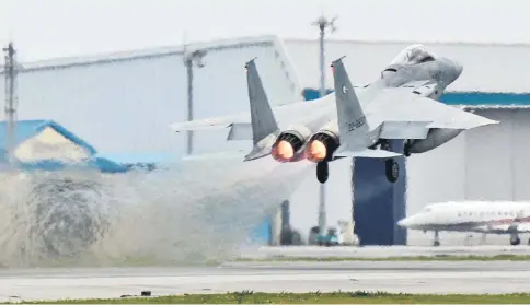  ??  ?? A Japanese Air Self Defense Force F-15 fighter scrambles at the Air Self Defence Force Naha base in Naha, Okinawa prefecture, Japan. — Reuters photo