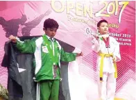  ??  ?? JAYDEN (kanan) berdiri atas podium.