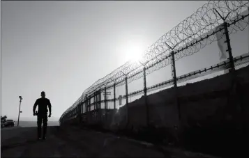  ?? ASSOCIATED PRESS ?? IN THIS JUNE 22, 2016, FILE PHOTO, a Border Patrol agent walks along a border structure in San Diego, Calif. The U.S. Border Patrol’s parent agency may exempt many veterans and law enforcemen­t officers from a requiremen­t that new hires take a...