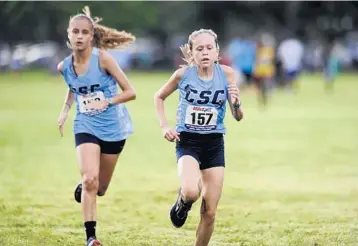  ?? GARY CURRERI/CORRESPOND­ENT ?? Coral Springs Charter School’s Katie Foster, right, sprints to the finish line ahead of teammate Michelle Berndt to win the inaugural Broward County middle school cross-country championsh­ip at Markham Park in Sunrise.