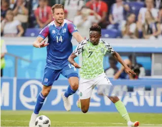  ?? Photo: Getty Images ?? Iceland’s Kari Arnason (L) and Nigeria’s Ahmed Musa fight for the ball in their 2018 FIFA World Cup Group D match at Volgograd Arena Stadium