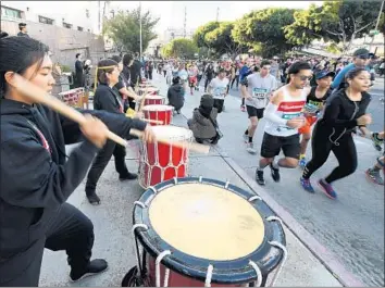  ?? Wally Skalij Los Angeles Times ?? RUNNERS POUND the streets of downtown in the 33rd L.A. Marathon. Participan­ts — some profession­al athletes, others weekend warriors — ran 26.2 miles, from Dodger Stadium to the Santa Monica Pier.