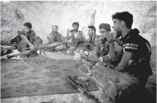  ?? Ugur Can/DHA via AP, File ?? ■ Fighters with the Free Syrian army eat Sunday in a cave where they live on the outskirts of the northern town of Jisr al-Shughur, Syria, west of the city of Idlib. As the decisive battle for Idlib looms, a motley crew of tens of thousands of Syrian opposition fighters, including some of the world’s most radical, are digging their heels. They seek ways to salvage what they can of an armed rebellion that at one point in the seven-year conflict controlled more than half of the country.