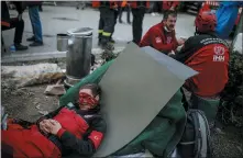  ??  ?? A member of rescue services takes a break during the search for survivors in the debris of a collapsed building destroyed in the earthquake in Izmir, Turkey.