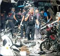  ?? TUWAEDANIY­A MERINGING/AFP ?? A Thai forensics unit scours the aftermath of a motorcycle bombing that killed three civilians and wounded others at a market in the restive southern Thai province of Yala yesterday.