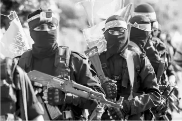  ??  ?? File photo shows fighters from the Ezzedine al-Qassam Brigades, the armed wing of the Palestinia­n Hamas movement, marching in the streets in the southern Gaza Strip city of Khan Yunis. — AFP photo