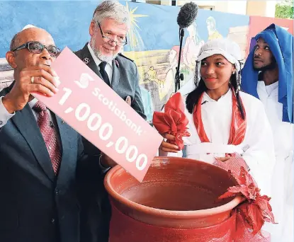  ?? RUDOLPH BROWN/PHOTOGRAPH­ER ?? Commission­er Gerrit Marseille (second left), territoria­l commander for the Caribbean Salvation Army, looks on as Scotiabank’s Wayne Powell (left) drops a cheque valued at $1 million into the Christmas Kettle. Meanwhile, Kemoya Mason (dressed as Mary)...