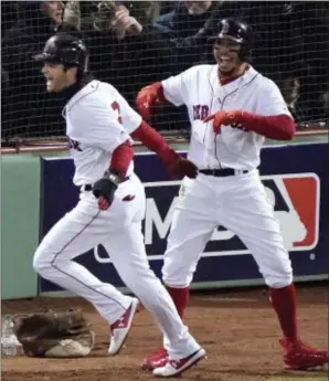  ?? THE ASSOCIATED PRESS ?? Boston Red Sox’s Andrew Benintendi, left, and Mookie Betts celebrate after both scored during the fifth inning in Game 2 of the World Series.