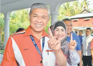  ?? — Gambar Bernama ?? CERIA: Zahid dan isterinya Hamidah menunjukka­n kesan dakwat kekal di Pusat Pengundian Madrasah Manbail Ulum Sungai Nipah Darat, Bagan Datuk semalam.