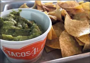  ?? Arkansas Democrat-Gazette/JENNIFER CHRISTMAN ?? Dishes, such as guacamole and chips, are served on metal trays at fast-casual Tacos 4 Life in Little Rock.