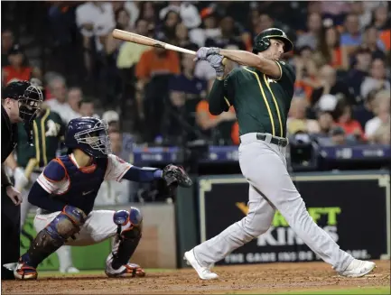  ?? DAVID J. PHILLIP — THE ASSOCIATED PRESS ?? Oakland’s Matt Olson, right, hits a two-run home run in Tuesday’s 21-7victory over Houston. Olson’s home run was one of five for the A’s.