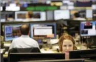  ?? THE ASSOCIATED PRESS ?? Traders work on the Mizuho Americas trading floor in New York.