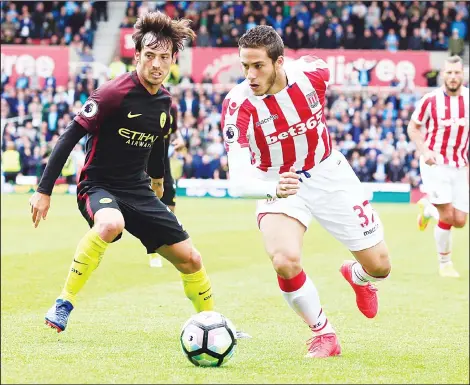  ??  ?? Manchester City’s Spanish midfielder David Silva (left), vies with Stoke City’s Egyptian midfielder Ramadan Sobhi during the English Premier League football match
between Stoke City and Manchester City at the Bet365 Stadium in Stoke-on-Trent, central...