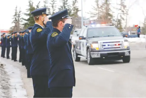  ?? DARREN MAKOWICHUK ?? Calgary police and first responders from all over the province held a parade around Falconridg­e on Monday as citizens continued to lay flowers at
the location where Sgt. Andrew Harnett was killed Thursday night after he was struck by a fleeing vehicle at a traffic stop in Calgary.