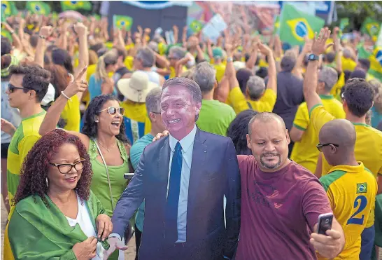  ?? Lucas landa/ reuters ?? Un manifestan­te se saca una selfie con una imagen de Bolsonaro, cerca de Copacabana