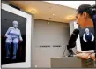  ?? AP/BEBETO MATTHEWS ?? Josephine Mairzadeh (right) uses a microphone to pose a question to a virtual presentati­on of Holocaust survivor Eva Schloss in the interactiv­e installati­on “New Dimensions in Testimony” at New York’s Museum of Jewish Heritage.