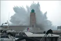  ?? BORIS HORVAT / AGENCE FRANCE-PRESSE ?? A wave breaks against a pier and a lighthouse as storm Ana smashes into southeaste­rn France on Monday.