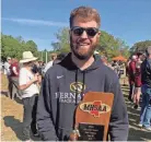  ?? LAURA BRADY ?? Hernando cross country coach Logan Clark holds the 2019 Mississipp­i High School Activities Associatio­n Class 6A state championsh­ip trophy. More recently, Clark was named the 2020 Mississipp­i Associatio­n of Coaches Girls’ Cross Country Coach of the Year.