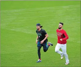  ?? ELISE AMENDOLA/AP PHOTO ?? Rajai Davis, the ex-New London High star, warms up during the Indians’ workout on Wednesday in Cleveland. Davis is waiting to find out if he will be on the Indians’ 25man roster for the upcoming American League divisional series against the Astros. Red Sox pitchers Joe Kelly, left, and Rick Porcello jog in the outfield during a workout on Wednesday at Fenway Park. Boston will host the winner of the Yankees-Athletics wild-card game in Game 1 of the American League divisional series on Friday night.