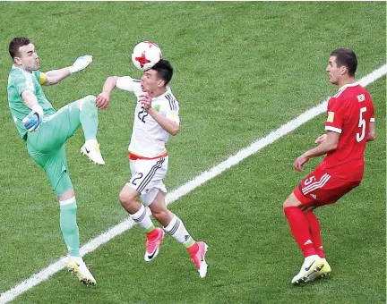  ??  ?? Mexico’s forward Hirving Lozano shoots to score the team’s second goal past Russia’s goalkeeper Igor Akinfeev during the 2017 Confederat­ions Cup Group A football match between Mexico and Russia at the Kazan Arena Stadium in Kazan on Saturday. (AFP)