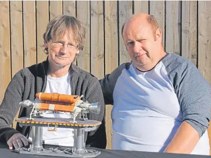  ??  ?? Ronnie Dignan and Rob Carson with the model spaceship.