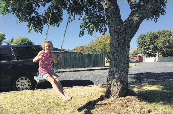  ?? Picture / Martin Johnston ?? Lucy Lord, 8, enjoys the swing her father put up for his family outside their home in Sandringha­m.