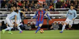  ?? —AP ?? BARCELONA: Barcelona’s Lionel Messi, center, runs with the ball past Celta’s defenders during a Spanish La Liga soccer match between Barcelona and Celta at the Camp Nou stadium in Barcelona, Saturday. Messi scored twice in Barcelona’s 5-0 victory.