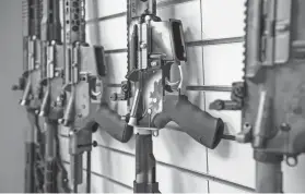  ?? LISA MARIE PANE/AP ?? AR-15 style rifles made by Battle Rifle Co., a gunmaker in Webster, Texas, line a wall in its retail shop. The gunmaker is one of more than 10,000 currently in the United States. Fears of limits on guns led to a surge in demand during President Barack...