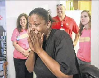  ?? PHOTOS BY BRUCE R. BENNETT / THE PALM BEACH POST ?? Tikisha Hobbs expresses her surprise at Christmas gifts given by St. Mary’s Medical Center staff Wednesday in Lake Worth. “I am so overwhelme­d right now,” said Hobbs. “We have Christmas gifts. We have a Christmas tree. We have life. What more could you ask for?”