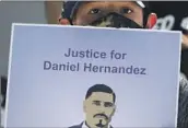  ?? Luis Sinco Los Angeles Times ?? MATTHEW HERNANDEZ, 8, holds a sign with a picture of his uncle, Daniel Hernandez, in June 2020.