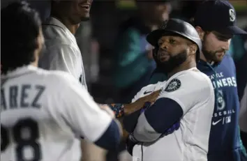  ?? AP ?? The Mariners’ Carlos Santana celebrates in the dugout after scoring against the Tigers on Oct. 4 in Seattle.