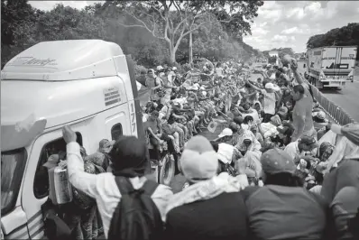  ?? UESLEI MARCELINO / REUTERS YEMEN ?? Central American migrants who are part of a caravan trying to reach the United States hitchhike on a truck along the highway as they continue their journey in Tapachula, Mexico, on Monday.