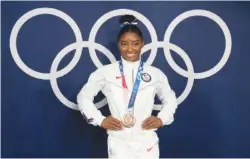  ?? AP PHOTO/NATACHA PISARENKO ?? Simone Biles poses wearing her bronze medal from balance beam competitio­n during artistic gymnastics Aug. 3, 2021, at the 2020 Summer Olympics in Tokyo.