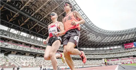  ?? — AFP ?? Hiroaki Kajisa (L) of Japan and his guide Satoshi Toyoshima compete in the men’s 1500m — T11 category during a para-athletics test event for the 2020 Tokyo Olympics.