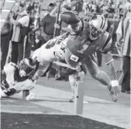  ?? Mike McCarn, The Associated Press ?? Carolina quarterbac­k Cam Newton dives for the end zone as Philadelph­ia’s Patrick Robinson (21) and Rodney McLeod (23) defend.