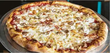  ??  ?? Pi Pizza’s The Business is topped with house-made Italian sausage, butter-thyme onions and feta.