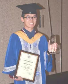  ??  ?? A Bachelor of Electrical Engineerin­g (Honors) graduate Wong Chang Seng shows the Chancellor Award he received from Taib.