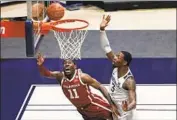  ?? Kathy Batten Associated Press ?? OKLAHOMA’S De’Vion Harmon shoots a layup past West Virginia’s Gabe Osabuohien in the second half.