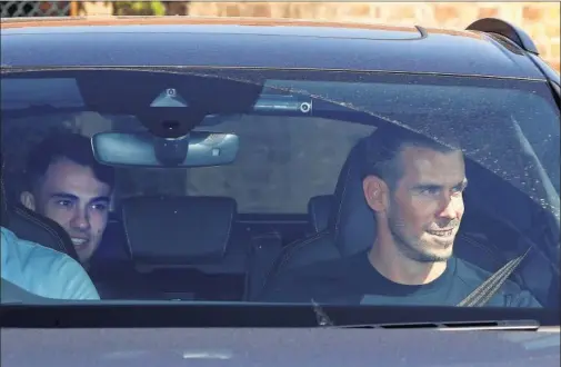  ??  ?? Bale, en la parte de delante y Reguilón, en el asiento trasero, a su llegada ayer a la ciudad deportiva de Enfield, al norte de Londres.