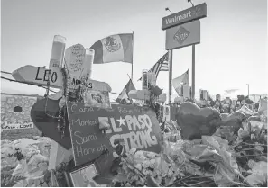  ?? MARK RALSTON/ AFP/ GETTY IMAGES ?? El Pasoans assert their strength in the face of violent racial hatred at a makeshift memorial where people pray and pay their respects to the victims of a mass shooting at the Cielo Vista Mall Walmart.