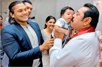  ??  ?? Now a grandfathe­r, Premier Rajapaksa kisses Nirvaan, son of Rohitha whilst mother Tatyana is in smiles