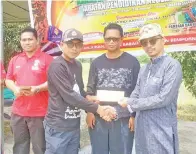  ??  ?? PENGETUA SMKA Keningau Haidon Hadi Sapiri (kanan) menyampaik­an hadiah kepada Rudy Amran johan pertanding­an memanah kategori terbuka urus setia, diiringi Pengerusi PEKDIS cawangan Semporna Nunhati Malizaman (dua kanan).